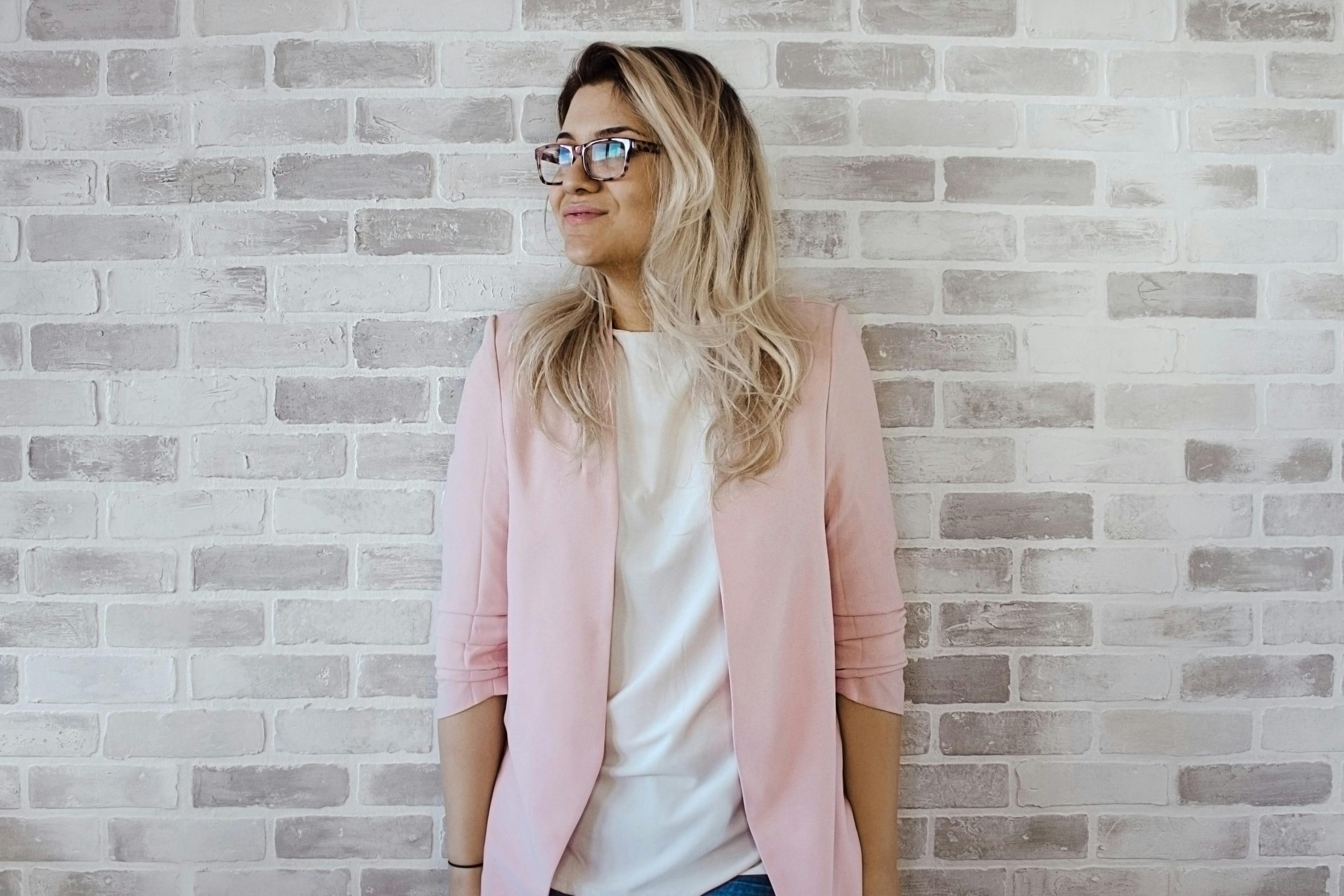 professional woman standing against brick wall