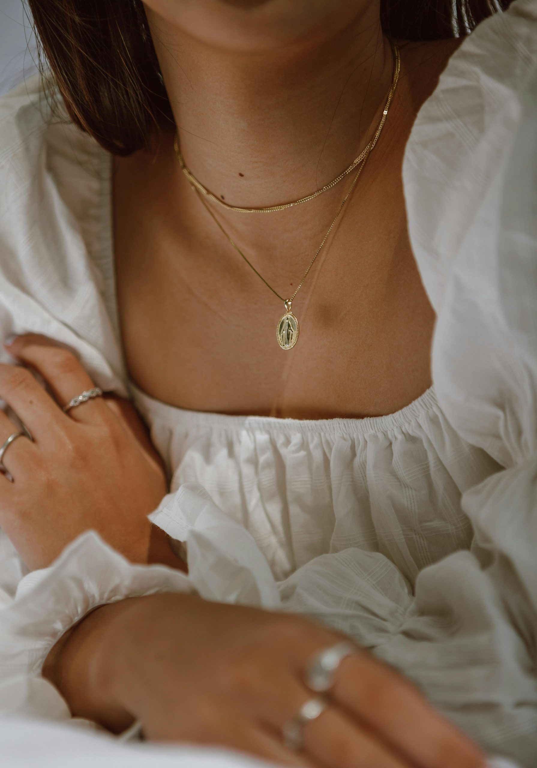 Decolletage view of woman wearing white cotton empire line dress