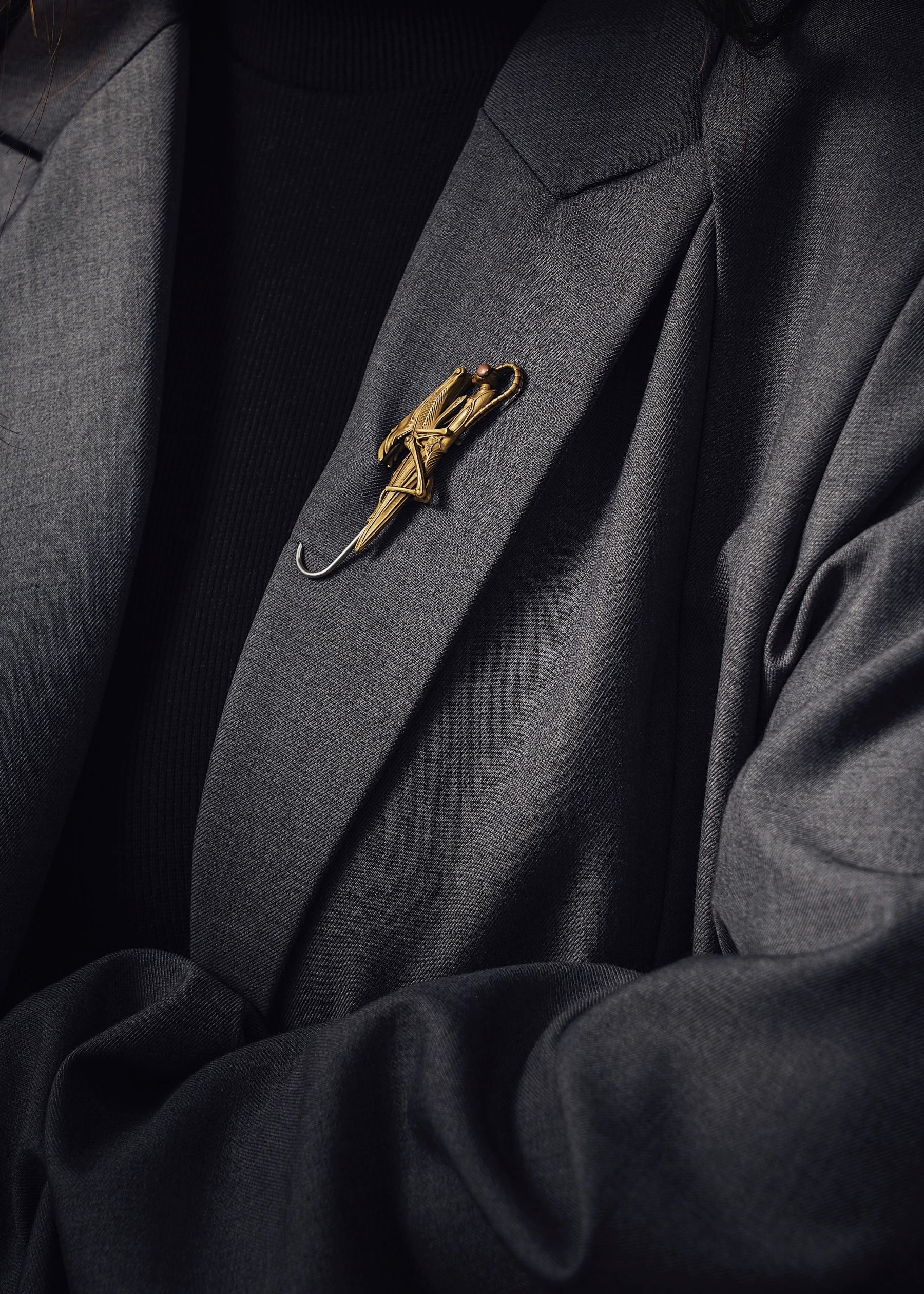 Professional grey suit jacket with gold brooch